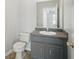Bathroom featuring a gray vanity, toilet, neutral wall color, and hardware in silver finish at 4411 Great Harbor Ln, Kissimmee, FL 34746