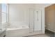 Bathroom featuring a bathtub, seamless glass shower, neutral tile, and window allowing natural light at 4411 Great Harbor Ln, Kissimmee, FL 34746