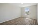 A sunlit, minimalist bedroom featuring modern floors and a view out of a bright window at 4411 Great Harbor Ln, Kissimmee, FL 34746