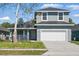 Two-story home featuring a two-car garage, manicured lawn, and covered porch at 4411 Great Harbor Ln, Kissimmee, FL 34746