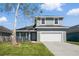 Two-story home featuring a two-car garage, manicured lawn, and covered porch at 4411 Great Harbor Ln, Kissimmee, FL 34746
