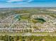 Expansive aerial view of a residential community featuring lakes and neatly arranged homes under a bright blue sky at 4842 Rockvale Dr, Kissimmee, FL 34758