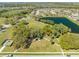 An aerial view of a neighborhood park with a large lake, sports field, playground, and walking path at 4842 Rockvale Dr, Kissimmee, FL 34758