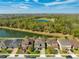 Aerial view of the home with a lake view, landscaping, well maintained yard, and mature trees at 4842 Rockvale Dr, Kissimmee, FL 34758