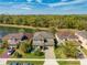 A beautiful, tan two-story home sits between a lake and a forest, making for a calm environment at 4842 Rockvale Dr, Kissimmee, FL 34758