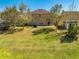 Back exterior of the home featuring a patio, basketball hoop, grill, and large backyard at 4842 Rockvale Dr, Kissimmee, FL 34758