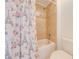 Bathroom with a white toilet and a tiled shower with a floral-patterned curtain at 4842 Rockvale Dr, Kissimmee, FL 34758