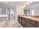 Well-lit bathroom featuring double sinks, a walk-in shower, and access to a walk-in closet at 4842 Rockvale Dr, Kissimmee, FL 34758