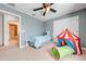 Well-lit bedroom featuring a ceiling fan, closet, and a view into an adjacent bathroom at 4842 Rockvale Dr, Kissimmee, FL 34758