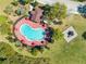 Overhead view of a stylish kidney-shaped community pool featuring lounge chairs, umbrellas, and a nearby playground at 4842 Rockvale Dr, Kissimmee, FL 34758