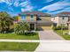 Two-story home boasts a manicured lawn, a paver driveway and mature palm trees for added curb appeal at 4842 Rockvale Dr, Kissimmee, FL 34758