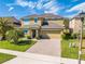 A two-story home with well-kept lawn, a driveway of paving stones, and stone accents by the entrance at 4842 Rockvale Dr, Kissimmee, FL 34758