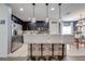 An open kitchen with modern stools lining the stone counter top, stainless steel appliances, and dark cabinets at 4842 Rockvale Dr, Kissimmee, FL 34758