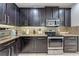 Beautiful kitchen with dark wood cabinets, granite countertops, stainless steel appliances, and mosaic backsplash at 4842 Rockvale Dr, Kissimmee, FL 34758