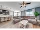 Open-concept living room featuring a large sectional, white shag rug, and a breakfast bar overlooking the kitchen at 4842 Rockvale Dr, Kissimmee, FL 34758