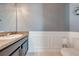 Modern powder room features a decorative mirror, white-panelled walls, granite counter top, and a white toilet and fixtures at 4842 Rockvale Dr, Kissimmee, FL 34758