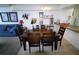 A dining area with a table for six with artwork on the walls and bar seating adjacent to the kitchen at 5004 Laguna Bay Cir # 54, Kissimmee, FL 34746