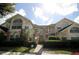 Two-story condo with a brick stairway, trimmed bushes, and bright yellow siding at 5004 Laguna Bay Cir # 54, Kissimmee, FL 34746