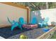 Cozy backyard featuring a brick fire pit surrounded by Adirondack chairs in a mulched area at 5201 Lake Hinden Cv, St Cloud, FL 34771