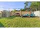 Landscaped backyard with a shed, firewood storage, and an inviting Adirondack chair seating area at 5201 Lake Hinden Cv, St Cloud, FL 34771