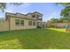 Spacious backyard with a well-maintained lawn, shed, and a two-story home featuring a balcony at 5201 Lake Hinden Cv, St Cloud, FL 34771