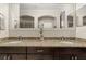 Elegant bathroom featuring dual sinks, granite countertops, dark wood cabinets and a large mirror at 5201 Lake Hinden Cv, St Cloud, FL 34771