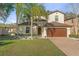 Charming two-story home with brick driveway, manicured lawn, and tropical landscaping at 5201 Lake Hinden Cv, St Cloud, FL 34771