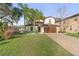 Charming two-story home with a well-manicured lawn and a brick driveway leading to a two-car garage at 5201 Lake Hinden Cv, St Cloud, FL 34771