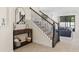 Welcoming foyer featuring decorative staircase, console table, and views into the living space at 5201 Lake Hinden Cv, St Cloud, FL 34771