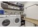 Well-organized laundry room with granite counters, storage shelves, and modern washer and dryer units at 5201 Lake Hinden Cv, St Cloud, FL 34771