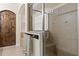 Stylish glass enclosed shower with built in seat next to a dark wood paneled door at 5201 Lake Hinden Cv, St Cloud, FL 34771