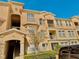 Attractive condominium building with balconies, manicured landscaping, and ample parking under a clear blue sky at 619 Terrace Ridge Cir # 619, Davenport, FL 33896
