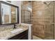 Bathroom with a tiled walk-in shower with glass, dark wood vanity, granite countertop, and neutral accents at 6592 Taxiway Cir, Orlando, FL 32822