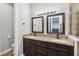 Double sink bathroom featuring dark wood cabinets, granite countertop, and framed mirrors at 6592 Taxiway Cir, Orlando, FL 32822