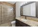 Bathroom features a glass walk-in shower and a dark wood vanity with granite countertop at 6592 Taxiway Cir, Orlando, FL 32822