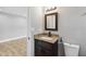 Bathroom featuring a dark wood vanity with granite countertop, a sink, toilet, and light fixture at 6592 Taxiway Cir, Orlando, FL 32822