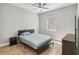 Bedroom features wood-look tile flooring, a ceiling fan, and a matching dark wood dresser and nightstand at 6592 Taxiway Cir, Orlando, FL 32822