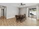 Well-lit dining room with wood flooring, six-seat table, and sliding glass door access to the outdoor patio at 6592 Taxiway Cir, Orlando, FL 32822