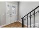 Welcoming entryway with a decorative glass door, wood-look tile flooring, and staircase with metal railing at 6592 Taxiway Cir, Orlando, FL 32822