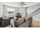 Inviting living room with neutral decor, comfortable seating, and a modern staircase with metal railing at 6592 Taxiway Cir, Orlando, FL 32822