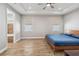 Spacious main bedroom with ceiling fan, tray ceiling, and ensuite bathroom featuring wood-look tile flooring at 6592 Taxiway Cir, Orlando, FL 32822