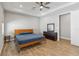 Bright main bedroom with tray ceilings, wood-look tile flooring, and a dark wood dresser and mirror at 6592 Taxiway Cir, Orlando, FL 32822