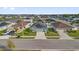 Neighborhood aerial view of a charming single-story home with solar panels, a stone accent, and a well-manicured lawn at 669 Persian Dr, Haines City, FL 33844