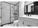 Modern bathroom featuring sleek black fixtures, a glass-enclosed shower, and elegant marble-look tile at 669 Persian Dr, Haines City, FL 33844