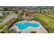 Aerial view of community pool with ample seating and shade, surrounded by lush landscaping and palm trees at 669 Persian Dr, Haines City, FL 33844