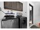 Well-equipped laundry room with washer, dryer, and upper cabinets for storage, offering convenience at 669 Persian Dr, Haines City, FL 33844
