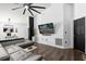 Modern living room featuring wood flooring, a sleek gray sofa, and a wall-mounted TV at 669 Persian Dr, Haines City, FL 33844