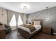 Serene bedroom featuring a stylish accent wall, modern lighting, hardwood floors, and a cozy sitting area at 669 Persian Dr, Haines City, FL 33844