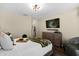 Serene bedroom featuring hardwood floors, modern lighting, a dresser with TV, and a cozy sitting area at 669 Persian Dr, Haines City, FL 33844