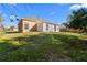 View of a spacious backyard with a home featuring brick accents and ample green space at 673 Leland Dr, Deltona, FL 32725